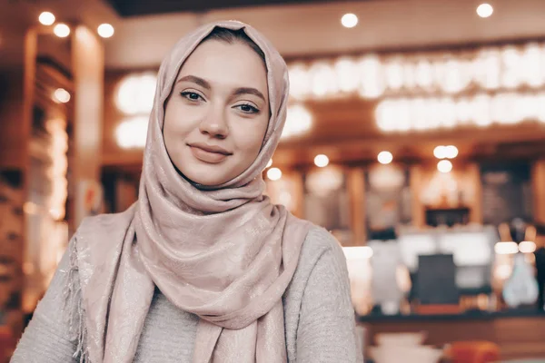 Beautiful Muslim girl in hijab smiling, waiting for her food in a restaurant — Stock Photo, Image