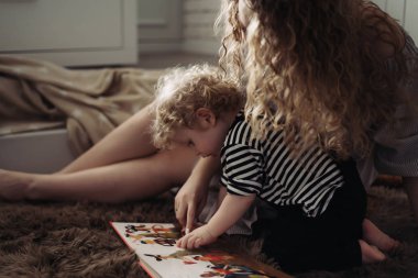 kıvırcık genç anne küçük oğlu yanındaki katta oturan, bir kitap okuma ve having fun