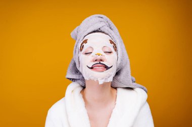 garip bir genç kız kendini, yüzünde bir nemlendirici maske bir köpeğin yüzüne beyaz önlük ile ilgilenir