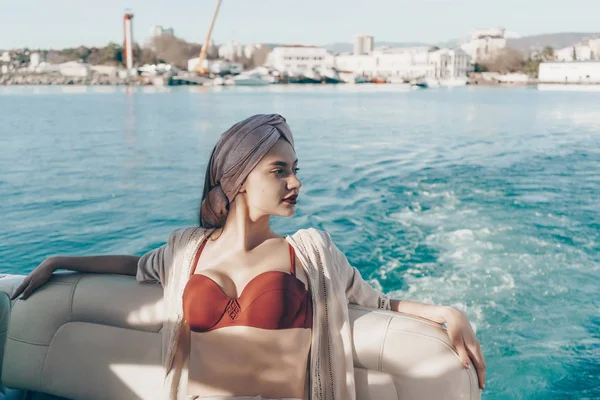 Una chica atractiva de lujo en las velas de ropa de verano de moda en el mar, disfruta de las vacaciones tan esperadas —  Fotos de Stock