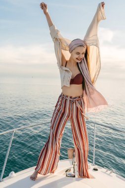 şık yaz giysileri mutlu gülen kız bir tatil sahiptir, onun beyaz yatta aittir