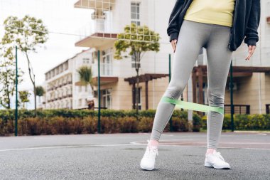 gri pantolon bacak kas egzersizleri spor alanında yapıyor ince kız