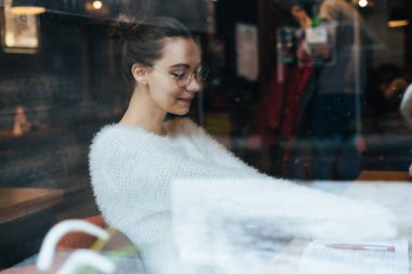 sınavlarına hazırlanıyor şirin kız öğrenci kafede oturan gözlüklü