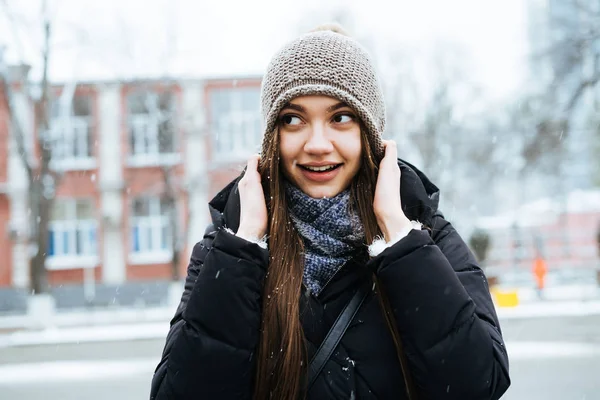 Charmantes lächelndes Mädchen in warmer Kleidung genießt das Winterwetter und spaziert durch die Stadt — Stockfoto