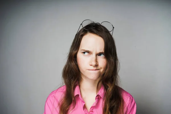 Jovem trabalhador de escritório grave mulher em uma camisa rosa pensa sobre o trabalho — Fotografia de Stock