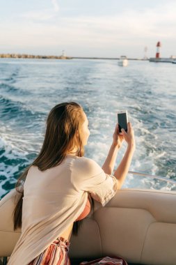 uzun saçlı bir kız akşam, deniz manzara ve günbatımı alır resimlerini Karayip Denizi üzerinde bir yatta yelken