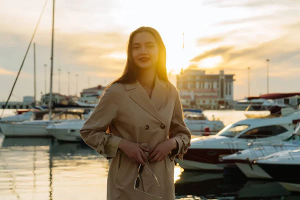 Atraente elegante jovem mulher desfrutando do calor e pôr do sol, no porto — Fotografia de Stock