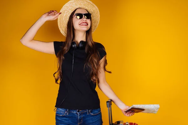 Sorrindo menina de cabelos longos em um chapéu e óculos de sol vai em uma viagem ao redor do mundo — Fotografia de Stock