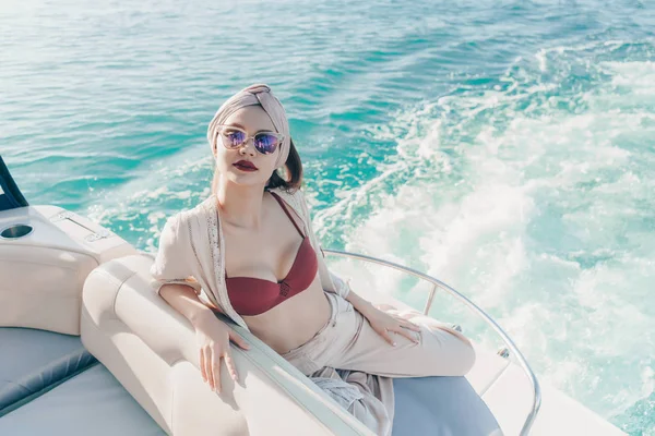 Una chica elegante de lujo en gafas de sol nada en el mar Caribe, disfruta de unas vacaciones —  Fotos de Stock
