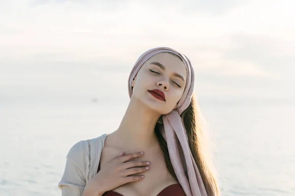 Una chica atractiva y tranquila con lápiz labial rojo cerró los ojos, disfruta del viaje por el mar — Foto de Stock