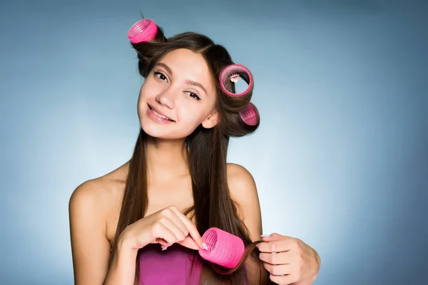 Young girl dresses on her hair curlers smiling — Stock Photo, Image