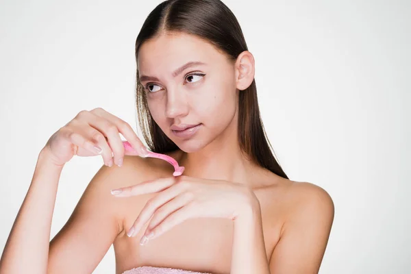 Kvinna på en vit bakgrund håller en rakhyvel i händerna — Stockfoto