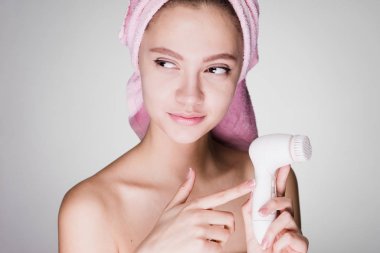 kadın beyaz bir arka plan üzerinde derin temizleme için bir fırça tutar