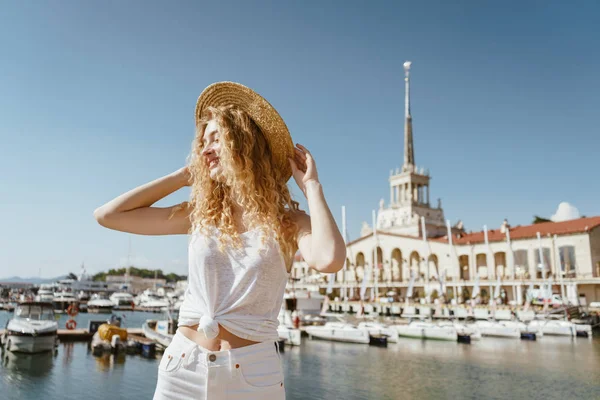 Chica con estilo en un sombrero irreconocible, se levanta contra el telón de fondo de la Estación Marítima de Sochi —  Fotos de Stock