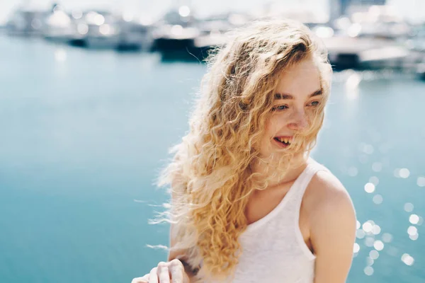 Śmiech młoda kobieta z loki na tle błękitnego morza — Zdjęcie stockowe