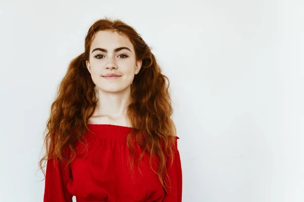 Menina ruiva bonita com sardas em um fundo branco em uma jaqueta brilhante . — Fotografia de Stock