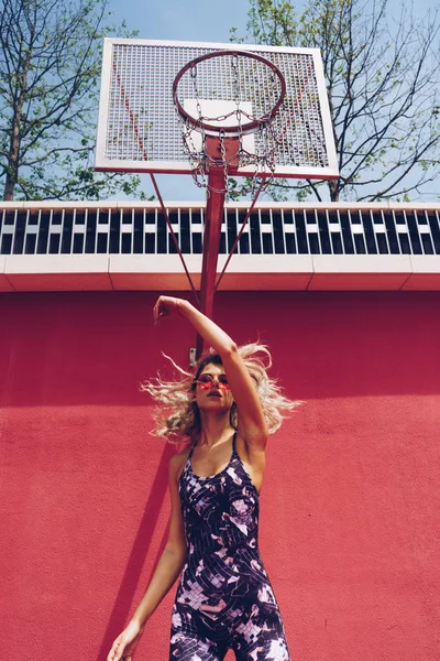 Atleta menina na moda pulando e bater na rede de um anel de basquete — Fotografia de Stock