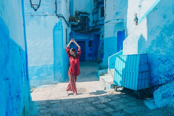 Encantadora joven en el vestido de terracota posando contra la pared azul del edificio del este del país — Foto de Stock