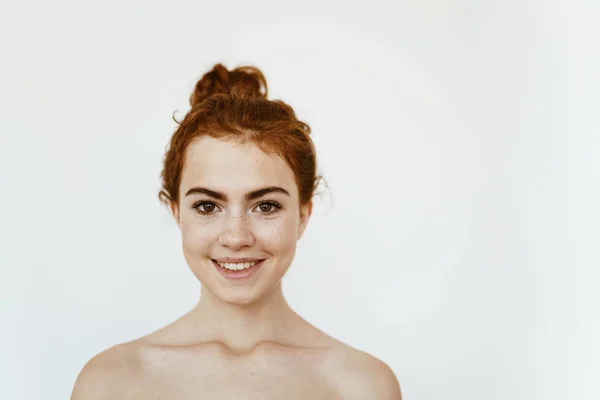 Jovem encantadora com cabelo encaracolado ruivo amarrado em um pão, com sardas em seu rosto sorrisos bonitos — Fotografia de Stock