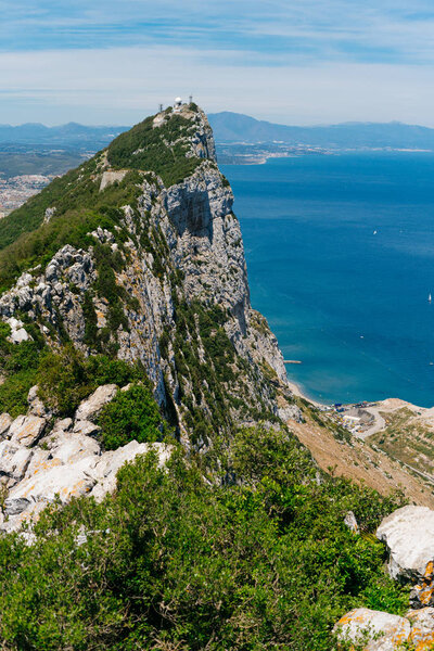 вид на океан на фоне горной вершины, покрытой зеленью
