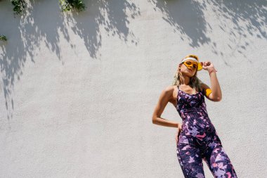 Atletizm öğrencisi duvarın arkasında duruyor.