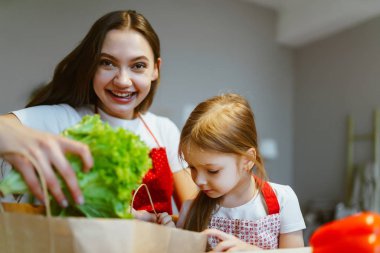 Anne ve kızı mutfakta sebze ayırıyor..