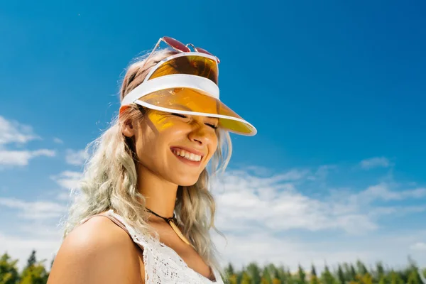 Menina de esportes em uma viseira squints ao sol — Fotografia de Stock