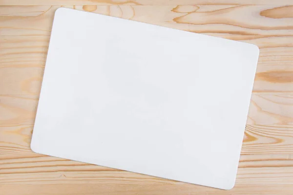 clean white sheet with rounded edges on a light-colored wooden background