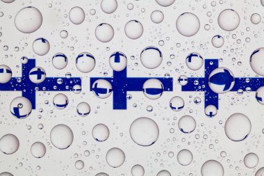 Finlandiya bayrağı bir cam arkasında yağmur damlaları ile kaplı.