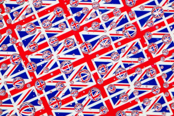 Yağmur damlaları ile kaplı bir cam arkasında Büyük Britanya'nın bayrakları.