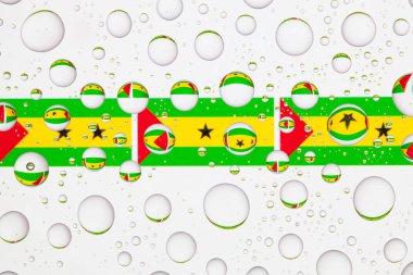 Sao Tome ve Principe bayrakları yağmur damlaları ile kaplı bir cam arkasında.