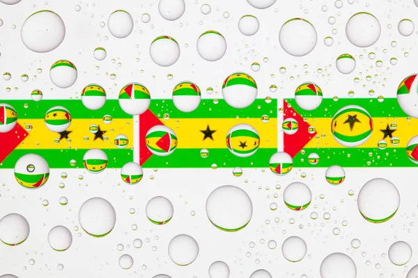 Sao Tome ve Principe bayrakları yağmur damlaları ile kaplı bir cam arkasında.