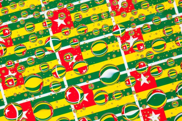 Togo, bayraklar bir cam arkasında yağmur damlaları ile kaplı. Togo bayrakları desen