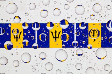 Barbados bayrakları yağmur damlaları ile kaplı bir cam arkasında.