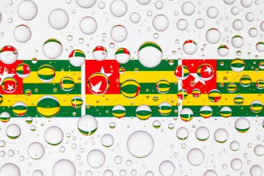 Togo bayrakları bir cam arkasında yağmur damlaları ile kaplı. 3D çizim