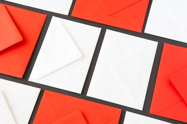 Composition with white and red  envelopes on the table. Different colored envelopes on the table.