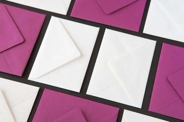 Composition with white and purple envelopes on the table. Different colored envelopes on the table.