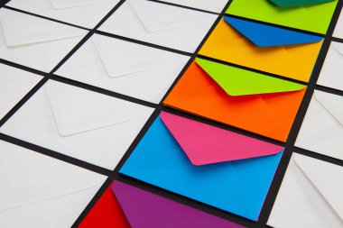 Masanın üzerinde beyaz ve renkli zarflar olan kompozisyon. Çeşitli bayramlar ve yıldönümleri için uygun fotoğraf.