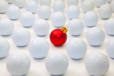 Desen beyaz golf topları ve masada kırmızı Noel dekorasyonu ile.