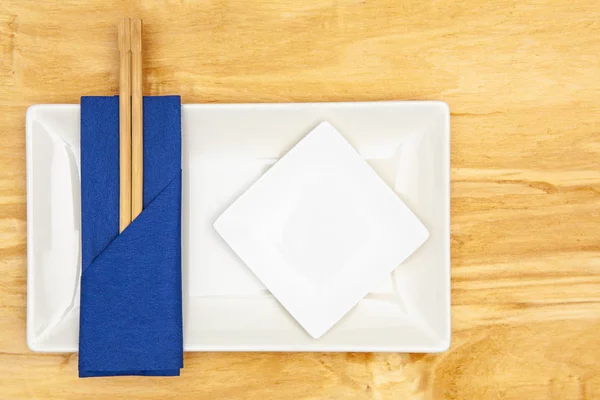 用深蓝色餐巾纸吃寿司的陶瓷碗和竹筷子 — 图库照片