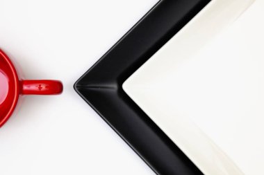 Farklı siyah beyaz tabak ve kırmızı beyaz ahşap masa bardakta. Üstten Görünüm. Düz yatıyordu görüntü.