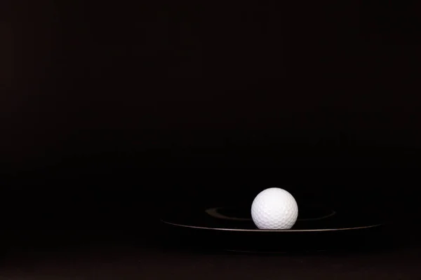 Plaque noire et balle de golf sur la table noire — Photo