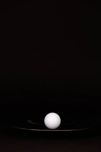 Svart tallrik och golfboll på det svarta bordet — Stockfoto