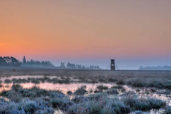 Охотник наблюдательной башни на поле на восходе солнца . — стоковое фото