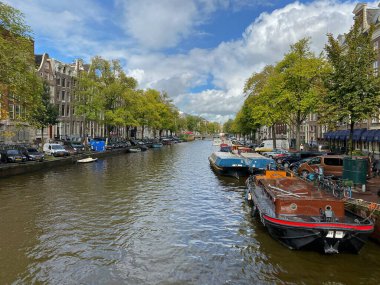 Amsterdam, Hollanda - 2 Ekim 2019: Tipik Hollandalı evleri ve yüzen evleri olan Amsterdam Kanalı, akşamları güzel su yansımaları olan tekneler, Hollanda, Hollanda.