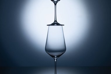 Mavi, temiz bir arka planda boş şarap kadehleri. Şeffaf şarap kadehleri boş.