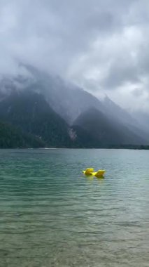 Kuzey İtalya 'daki güzel Lago del Predil' de iki sarı plastik şezlong.,