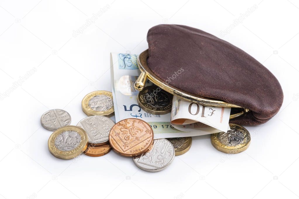 UK money in old purse, a mixture of pound coins, smaller coins and notes in a purse which is overflowing