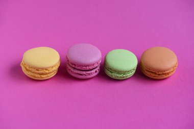 Fucsia arka plan üzerinde birkaç çok renkli macaroons
