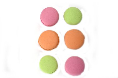 Beyaz arka plan üzerinde izole yeşil, turuncu ve pembe Fransızca macaroons